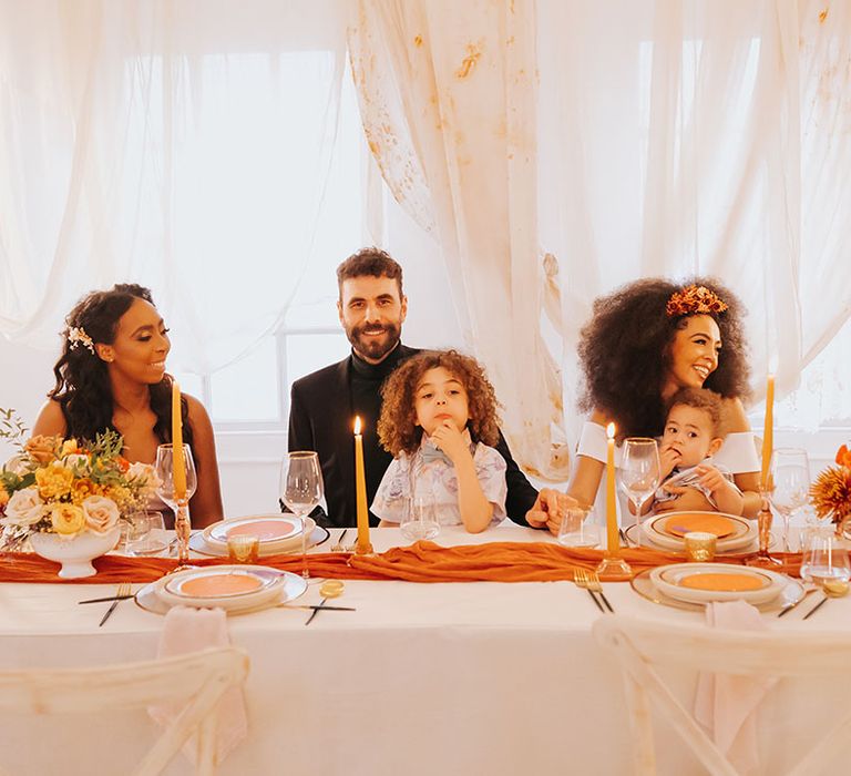 Family wedding with page boys sat on the bride and grooms lap with draping behind the top table