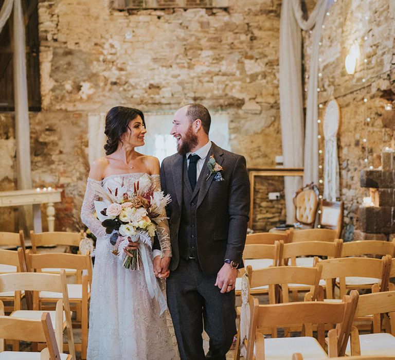 Bride and groom gaze at eavh other as they pose in the ceremony room at Ash Barton Estate wedding venue