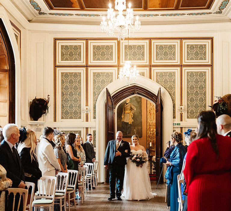 Drumtochty Castle wedding venue with crystal chandelier and grand double doors where bride and father of the bride make their entrance