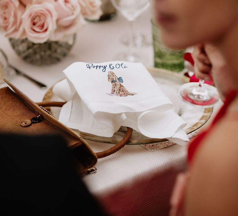 White embroidered napkins with picture of dog and couple names  