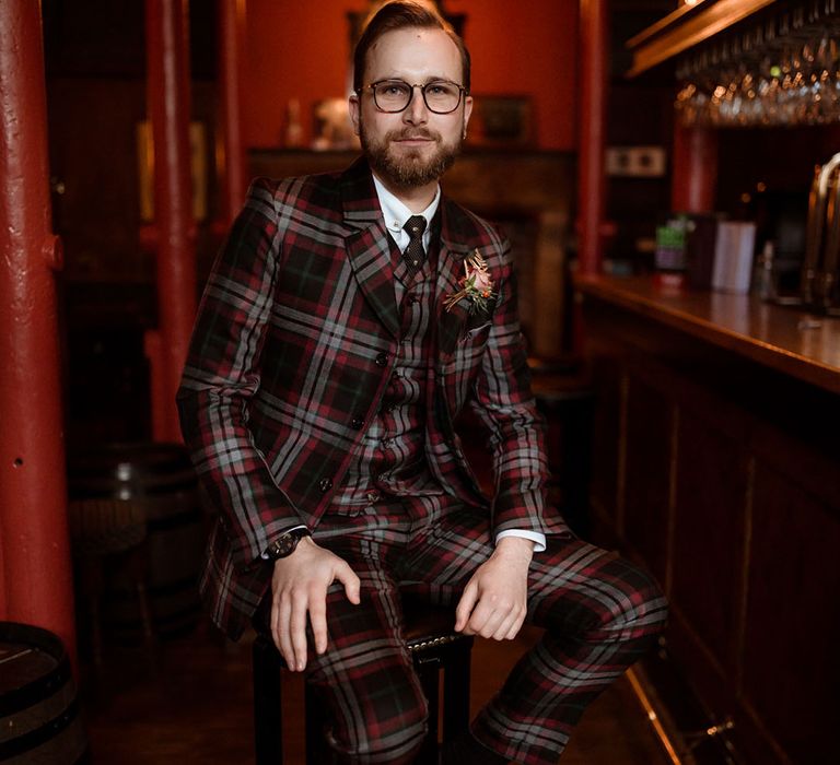 Groom wears bespoke tartan suit complete with floral buttonhole and vintage Dr Marten shoes 