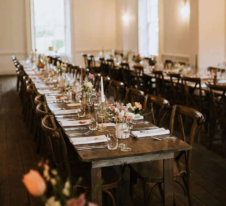 Rustic Aswarby Rectory complete with wooden banquet tables and simply potted floral bouquets lining tables 