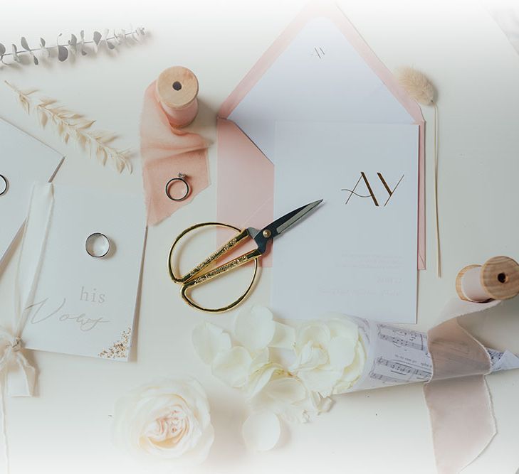 Neutral toned flatlay complete with wedding stationery and undertones of pastel pink 