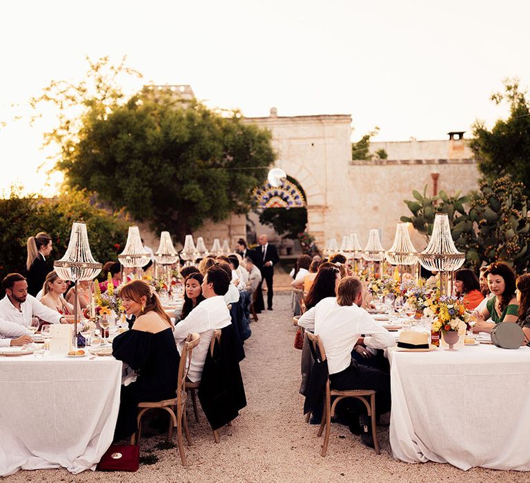 Chandelier installations hang above tables for the wedding breakfast at the rustic destination wedding 