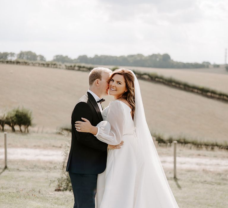 Bride & groom embrace outdoors in fields for couples portraits 