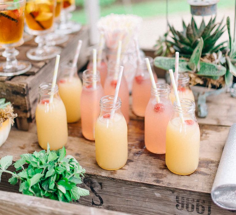 Pale pink and pale yellow mocktails with white straws in milk bottles 