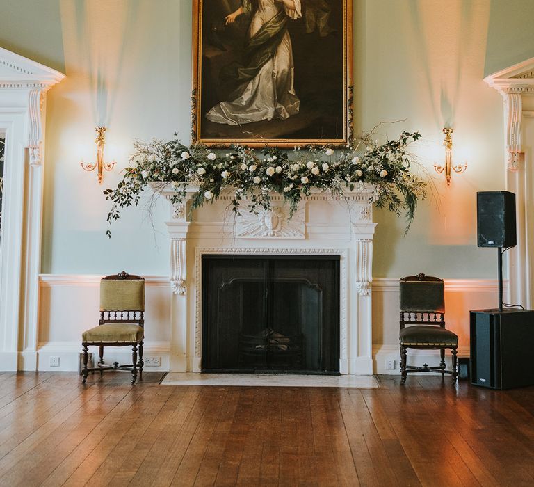 Kirtlington Park wedding venue with grand fireplace and portraits 