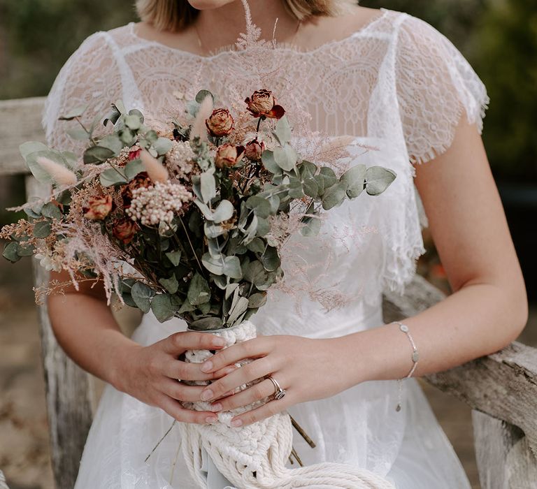 Bride in a boho wedding dress with a dried flower headband and dried flower bouquet with macrame bouquet tie 