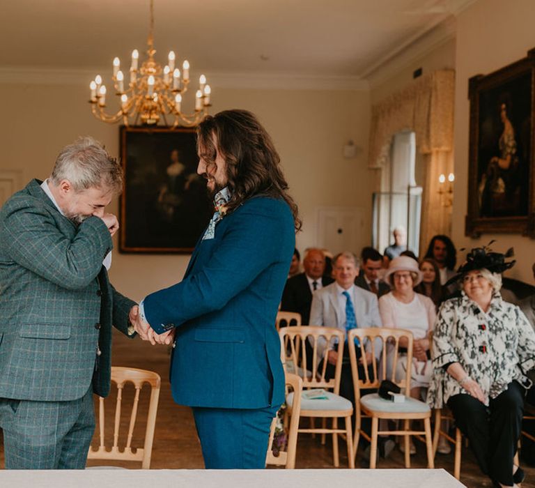 Grooms laugh during wedding speeches at the Cambridge Cottage for Kew Gardens wedding 