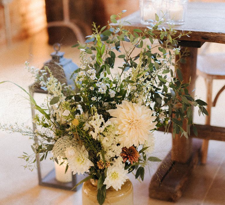 Wedding flower arrangement in cream vase with all white wildflowers and home gown flowers 