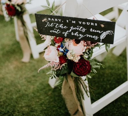 Chalkboard wedding sign wedding chair decor idea with colourful flowers decorating the ceremony chairs for outdoor wedding 