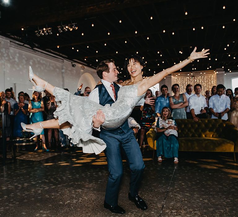 Groom lifts his bride during first dance at Trinity Buoy Wharf