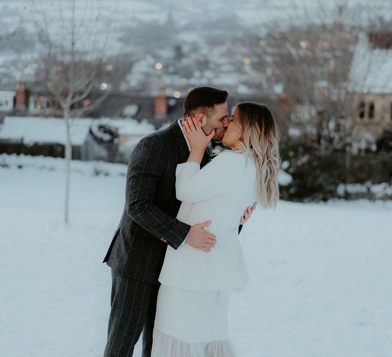 Winter wedding for the bride and groom as they share a kiss together after their registry office civil ceremony 