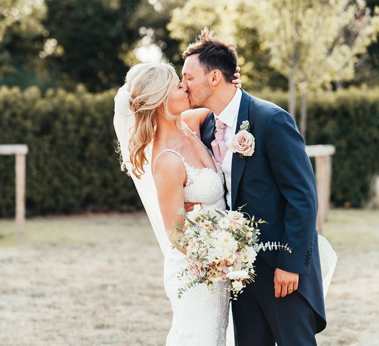 The bride and groom share a kiss together for their couple portraits 