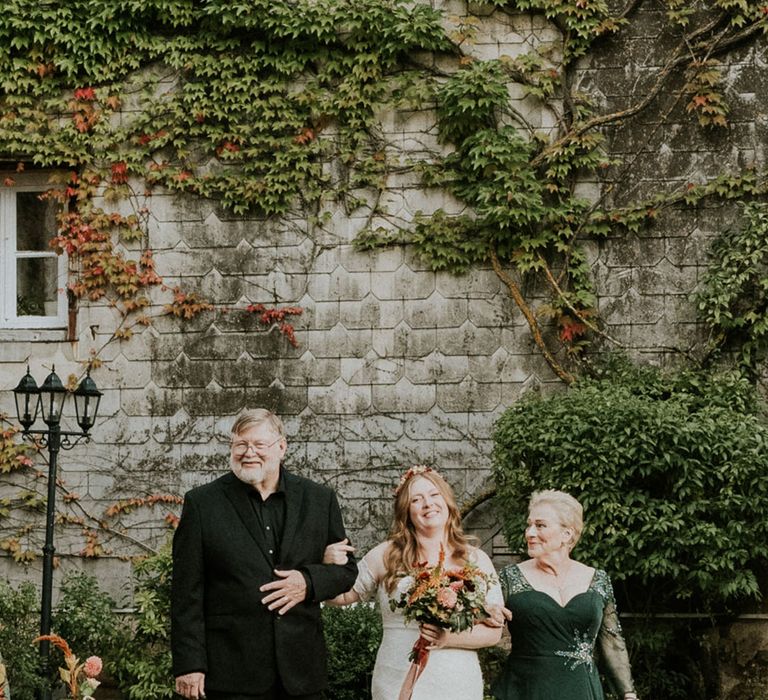 mother and father of the bride walking their daughter down the aisle at French destination wedding 