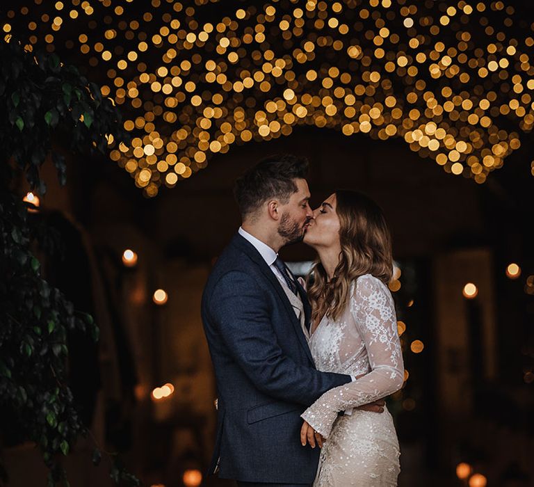 Magical winter wedding at Stone Barn in Gloucestershire with the bride and groom sharing a kiss together