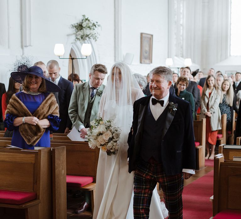 Father of the bride in tartan trousers walking down the aisle with bride in Jessica Bennett wedding dress