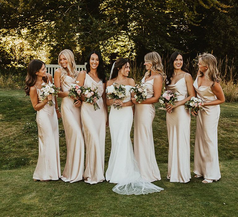 Bridal party in champagne gold satin bridesmaid dresses with the bride in a Halfpenny London wedding dress 