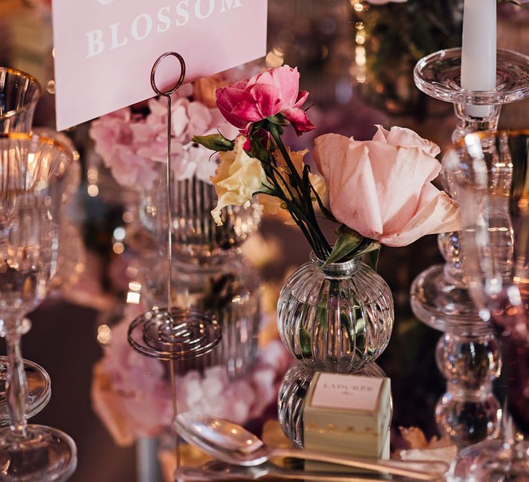 Pink wedding table name sign with pastel wedding flower arrangements at Four Seasons Hampshire 