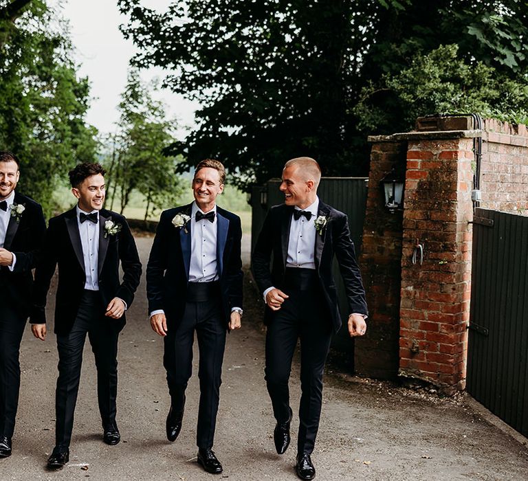 Groom and groomsmen in blue and black tuxedos 