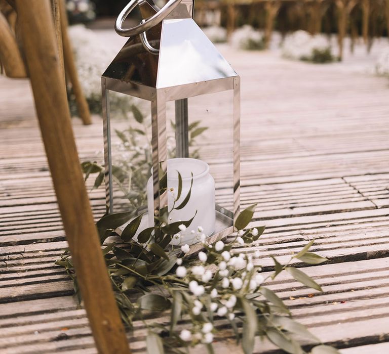 Silver lantern aisle decor with white flowers and foliage 