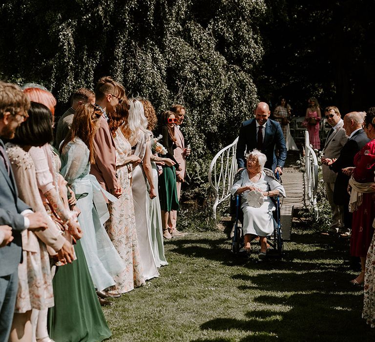 Grandma throws confetti on the gras as flower girl 