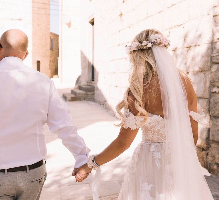 Boho pastel wedding theme in Croatia with bride in boho off the shoulder floral wedding dress with groom in white shirt 