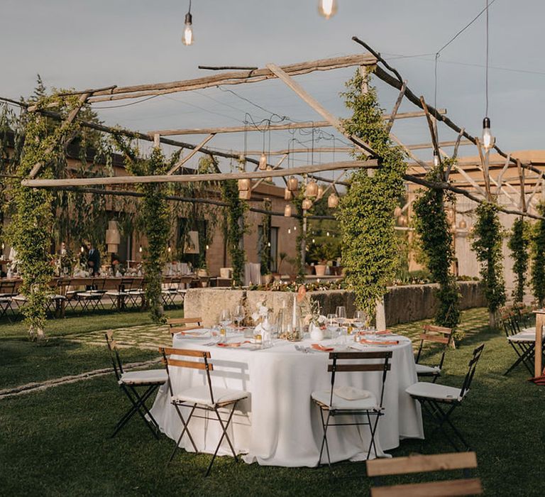 Outdoor al fresco wedding breakfast at destination wedding with boho styling with rustic lighting and a terracotta palette 