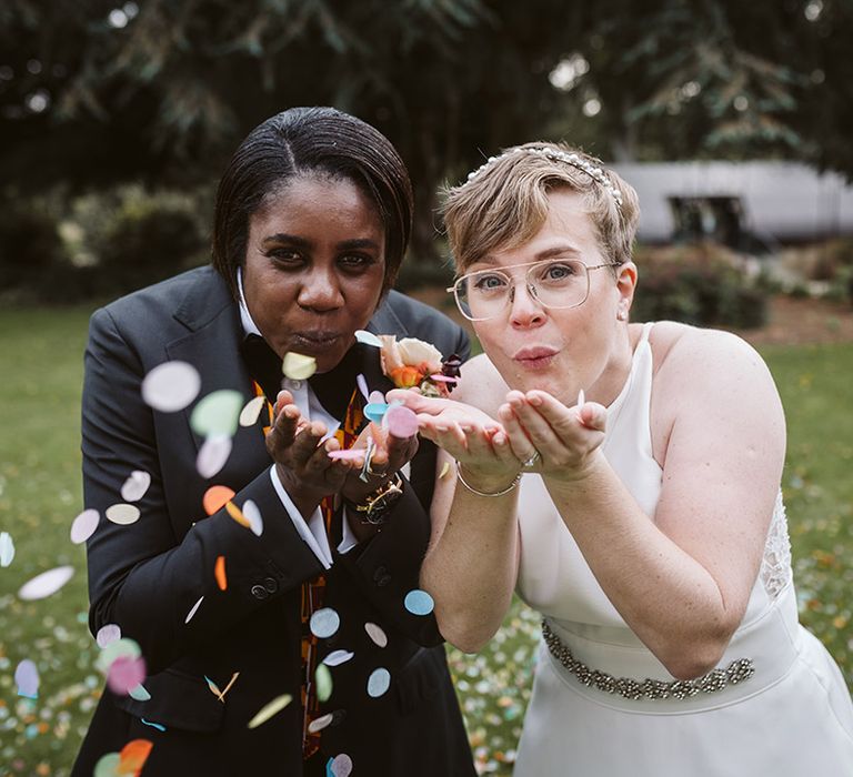 Brides blow the confetti for cute couple portrait 