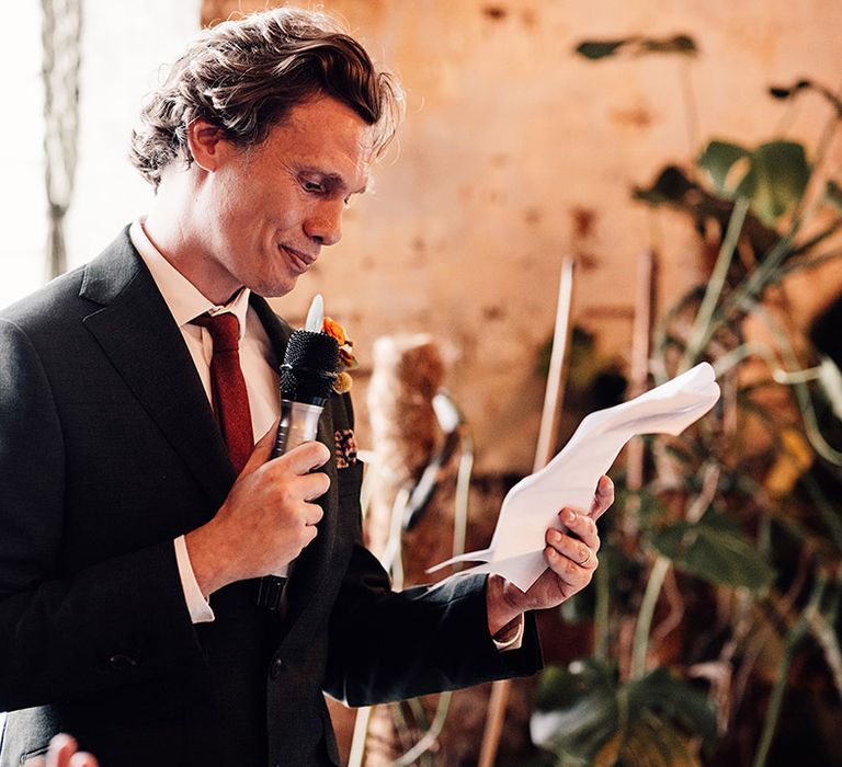 The groom stands as he reads out his wedding speech 