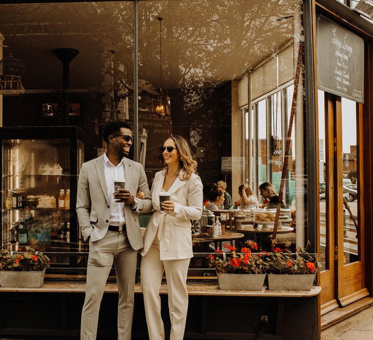 Bride and groom enjoying coffee outside their favourite cafe after their city elopement 