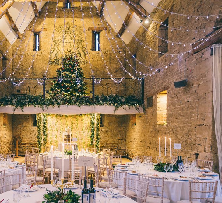 The Great Tythe Barn wedding reception with festive wedding decor, fairy lights and Christmas trees 