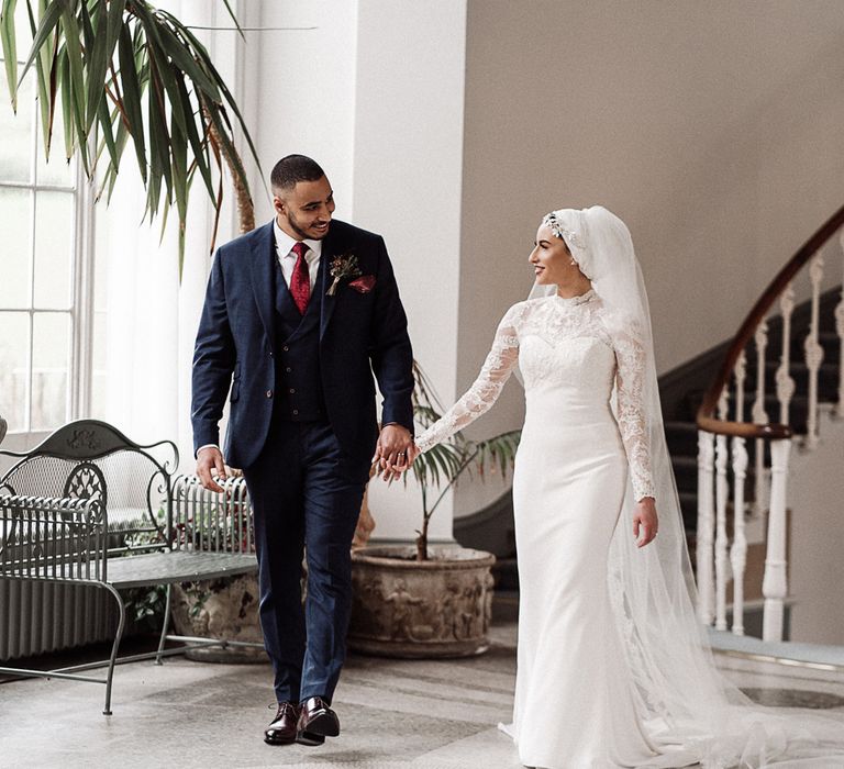 Bride and groom holding hands at Islamic wedding 