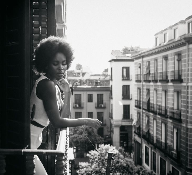 Black & white image of bride stood on balcony 