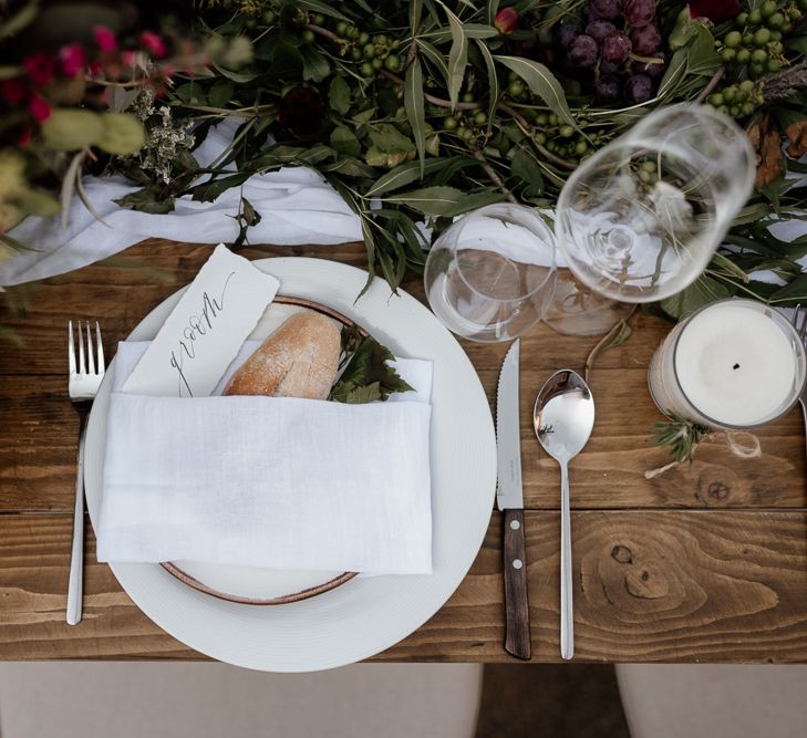 Place setting with fresh bread wrapped in a linen tablecloth