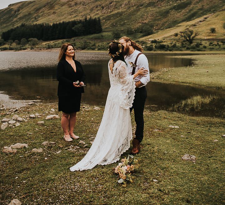 Bride & groom kiss during wedding ceremony in the Lake District