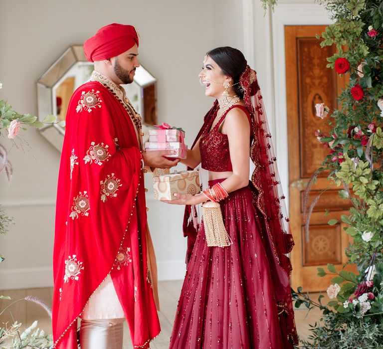 Bride & groom stand together under floral archway