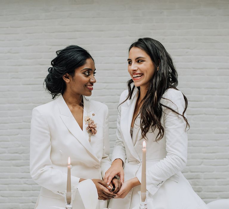 Brides cutting their one tier naked wedding cake together for all white wedding inspiration