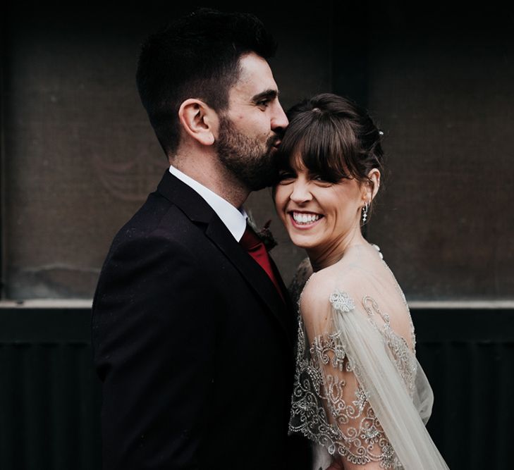 A close up portrait of a bride and groom. The bride wears a homemade wedding dress.