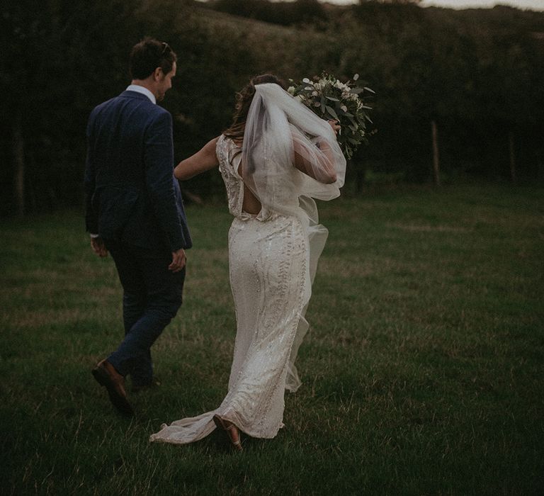 Bride & groom walk together outdoors on their wedding day