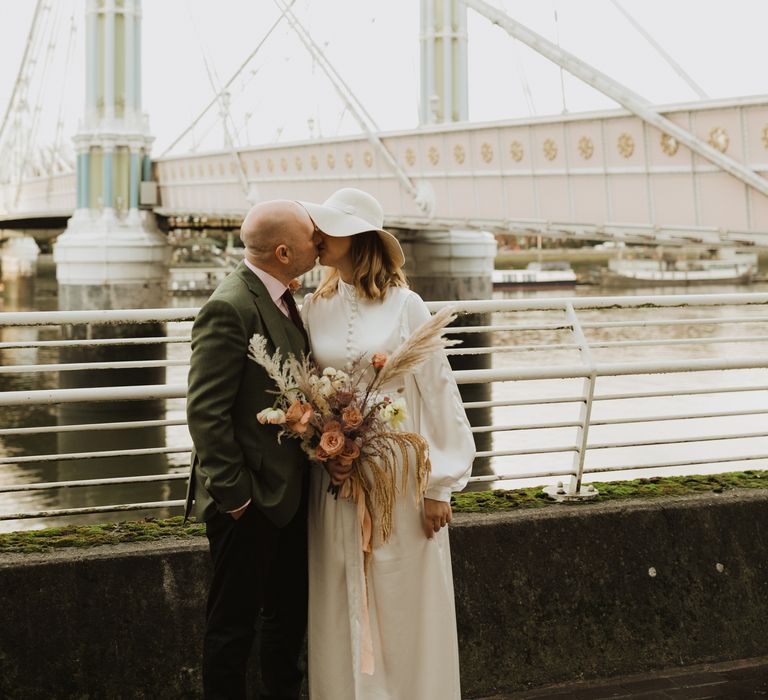 Bride & groom kiss on bride on their wedding day