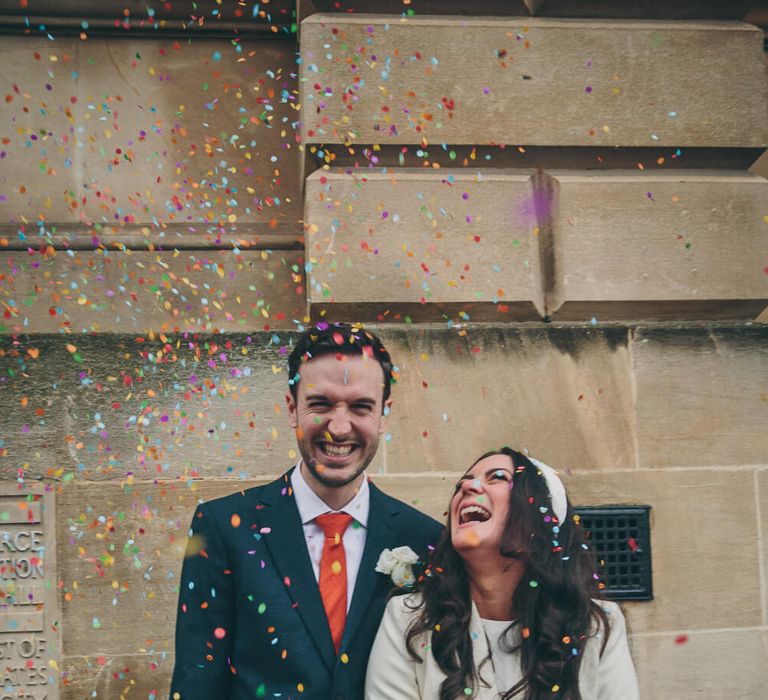 Bride and groom on their wedding day bride wears short wedding dress groom wears red tie