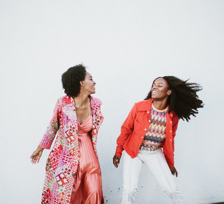 Brides-to-be in vibrant outfits dancing at their engagement photoshoot 