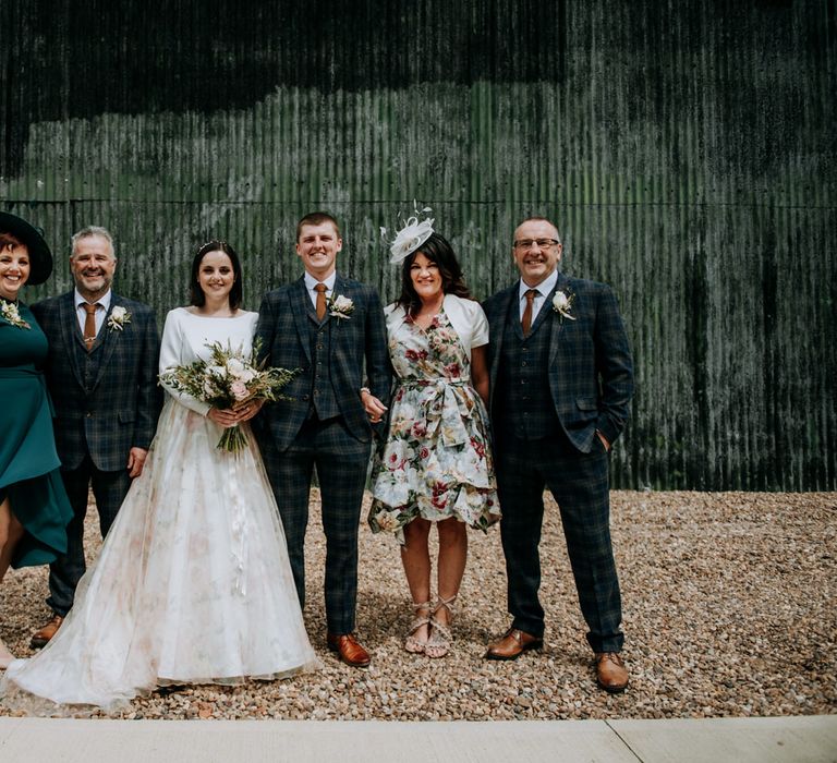 Portrait of the mother and father of the bride and groom with the happy couple 