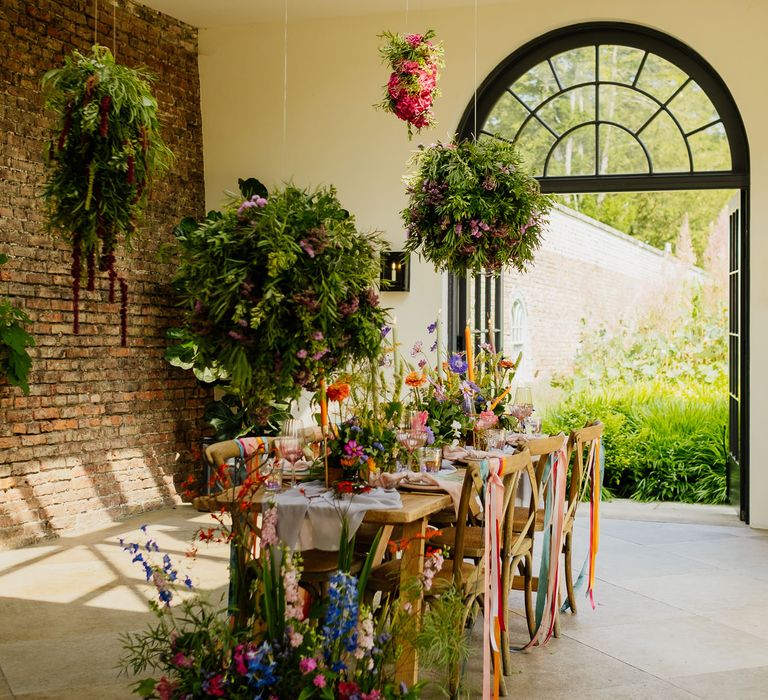 Intimate tablescape at Middleton Lodge Fig House with Hanging installations, flower box centrepieces, ribbon chair backs and taper candles 