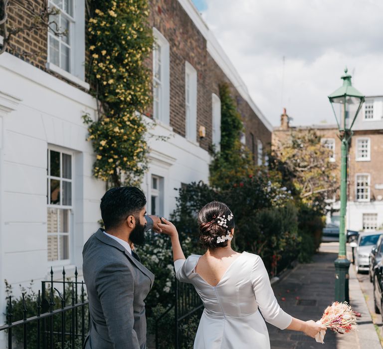 Bride & groom walk together through the streets of Chelsea on their wedding day