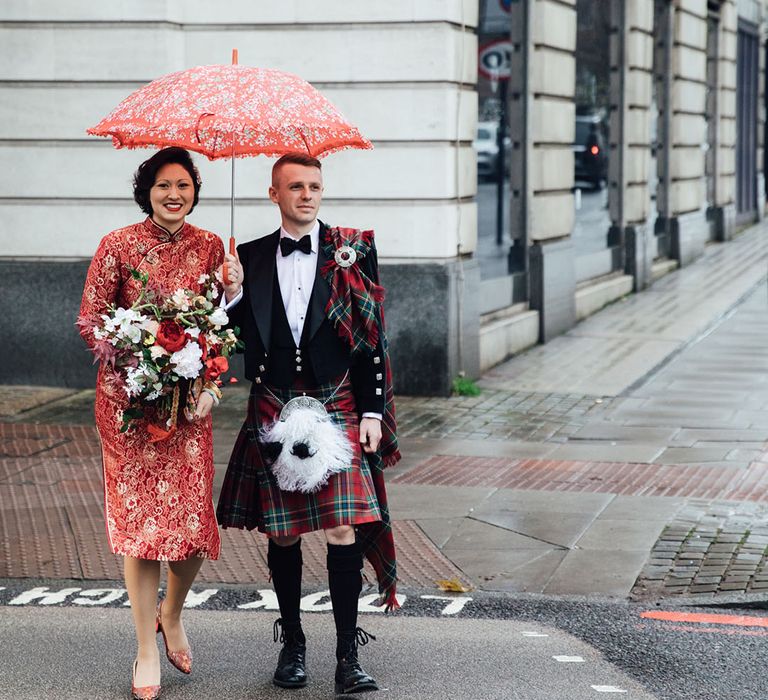 Red umbrella for couple at rainy London wedding