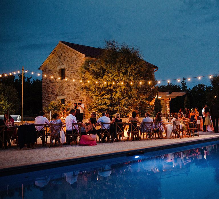 Villa lit up at night with fairy lights next to swimming pool in Croatia