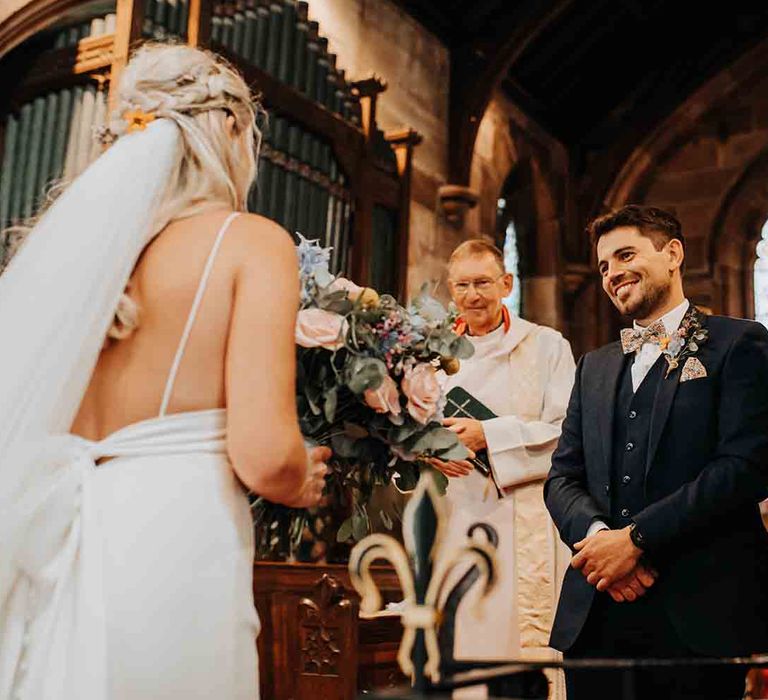 Groom greets bride at the church alter 