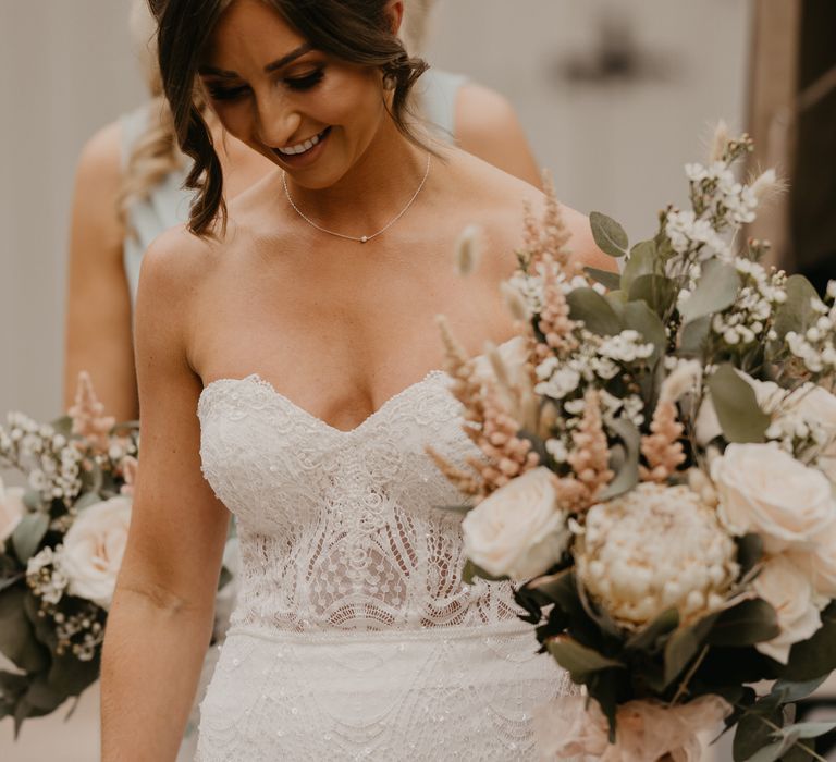 Bride wears Enzoani wedding gown whilst carrying white floral bouquet complete with greenery | Mark Bamforth Photography